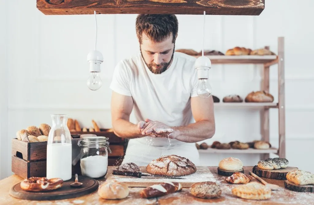 Baker with a variety of delicious freshly baked bread and pastry