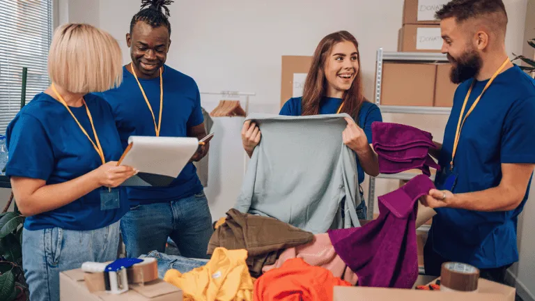 Diverse volunteers working in a charity donation center and packing clothes and food