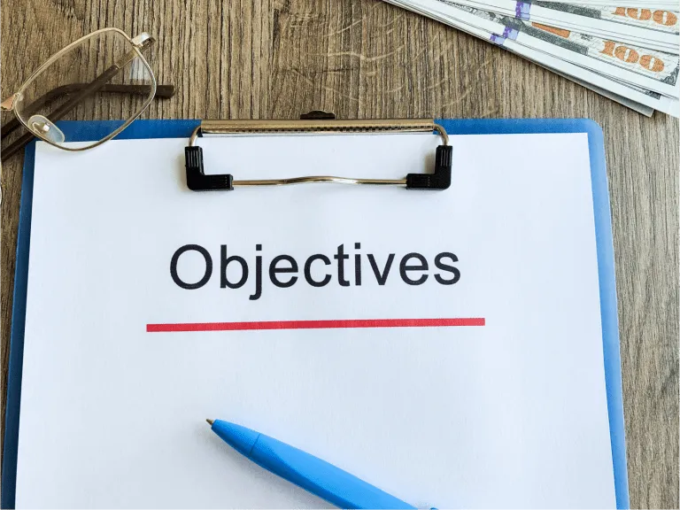paper with text objective on wood table