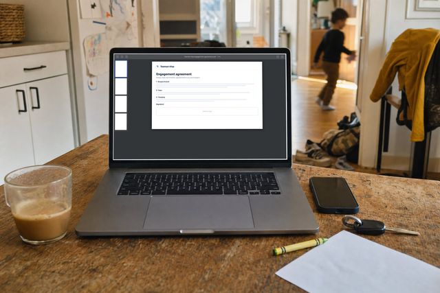 A Tasman Visa engagement agreement open as a PDF on a kitchen table, a child running past in the hallway
